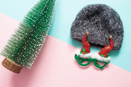 Christmas concept with ornaments and party accessory on pink and green backgroundの写真素材