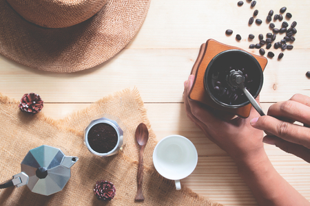 Creative flat lay of manual style coffee maker, Wooden coffee grinder and accessories on wooden tableの写真素材