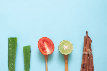 Creative flat lay of natural beauty concept, aloe vera, tomato, lime and cinnamon sticks , Health and skin care ingredientsの写真素材