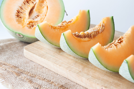 Sliced fresh Japanese melon, orange melon on cutting board. Selective focusの写真素材