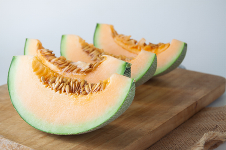 Sliced fresh Japanese melon, orange melon on cutting board. Selective focusの写真素材