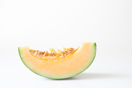 A piece of sliced orange melon or Japanese melon isolated on white backgroundの写真素材