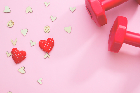 Creative flat lay of health or insurance concept. Hearts and fitness equipment on pink backgroundの写真素材