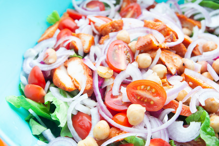 Salad with grilled chicken, cherry tomatoes, corn salad, chick peas, fresh lettuce and onion. Home made food. Concept for a tasty and healthy meal. Top view. Close up.の写真素材