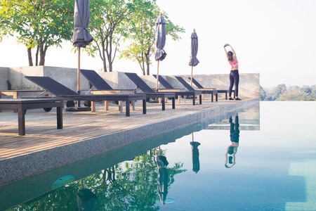 Sporty asian woman exercising near swimming pool. Healthy lifestyle conceptの写真素材
