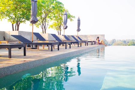 Landscape of swimming pool on the roof top with asian woman relaxingの写真素材