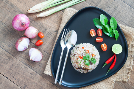 Creative flat lay of special Thai Food. Fried rice with mackerel, chilli, lime leaves, onion and Thai herbs.の写真素材