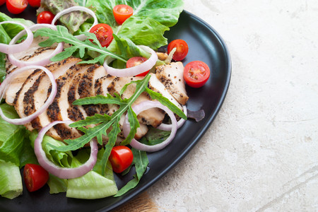 Close up healthy salad with grilled chicken, onions and tomatoes. Healthy food.の写真素材