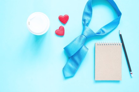 Creative flat lay of Father's Day concept. Necktie and notebook  on pastel colour background