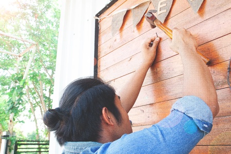 Asian man nailing wooden wall. Home improvement conceptの写真素材