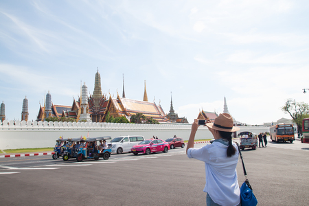 Bangkok, Thailand - April 16, 2019 : Pretty asian woman with the grand palace in background.  Travel in Bangkok, Thailandのeditorial素材