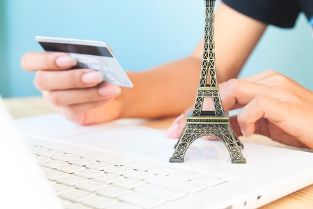 Woman's hands using laptop and credit card for booking or reservation hotel and flight for Parisの写真素材