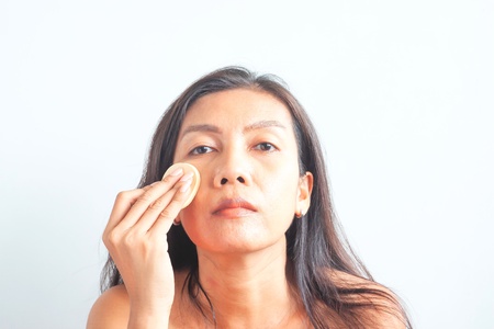 Asian woman applying foundation powder on face, skin problem. Beauty and Healthの写真素材