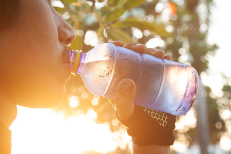 Close up man drinking water from bottle. Lifestyle conceptの写真素材