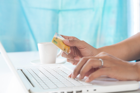 Hands holding credit card and using laptop computer. Online shopping, E-payment or internet bankingの写真素材