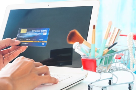Hands holding credit card and using laptop computer. Beauty online shopping, E-payment or internet bankingの写真素材