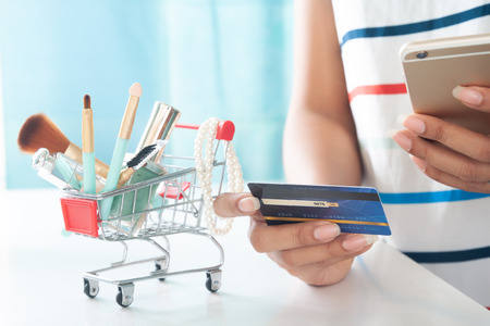 Woman using smartphone and credit card shopping beauty items. Online shopping, e-paymentの写真素材