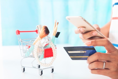 Woman using smartphone and credit card shopping beauty items. Online shopping, e-paymentの写真素材