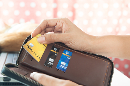 Woman hands holding purse and picking credit card. E-business payment conceptの写真素材