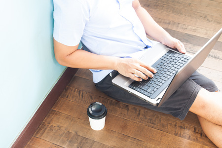 Man in casual style clothing using laptop computer. Technology and lifestyle conceptの写真素材