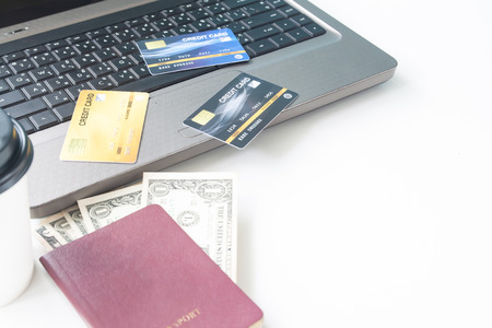 Credit cards onlaptop and passport with dollar bills on desk. Online shopping. booking, buying, paying, ordering, commercial concept. Shopping online and credit card. Selective focus.の写真素材