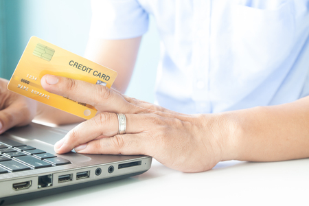 Online payment, Man's hands holding a credit card and using laptop for online shoppingの写真素材