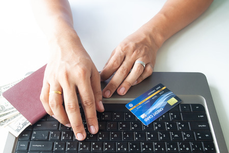 Man hands using laptop computer and credit card. Passport and moneyの写真素材
