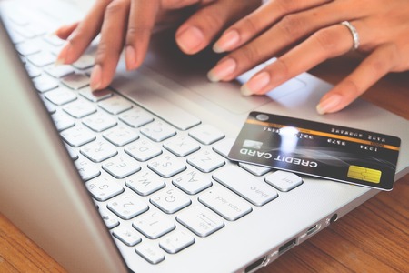Woman hands using laptop computer with plastic credit card on keyboard. Selective focus . Online shopping, paying, buying, e-payment and technology concept.の写真素材