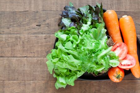Top view of fresh and colourful vegetables on wooden table with copyspaceの写真素材