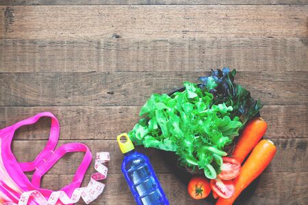 Diet and fitness concept.  Healthy foods and fitness equipments on wooden background with copyspaceの写真素材
