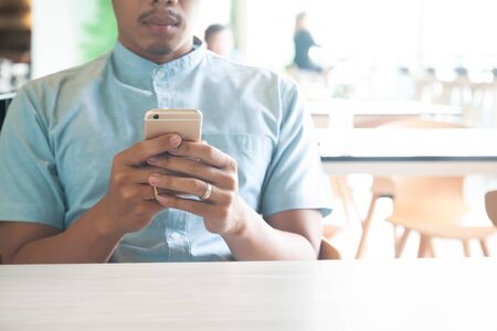 Man using mobile phone sitting in cafe. Smart life. Technology and people conceptの写真素材