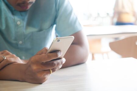 Man using smart phone sitting in cafe. Smart life. Technology and people conceptの写真素材