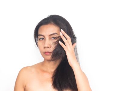 Age 40+ Asian woman with problem about long hair on white background. Health and surgery conceptの写真素材