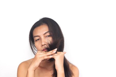 Age 40+ Asian woman with problem about long hair on white background. Health and surgery conceptの写真素材