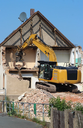 demolition of an old house with a chain excavator, half doneの写真素材