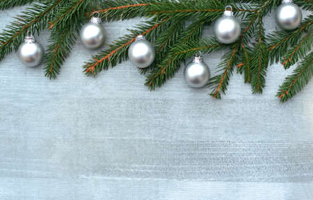 silver colored Christmas background with spruce branches and small silver balls on woodの写真素材