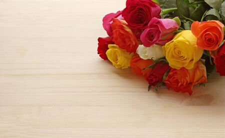 bright wood background with a bunch of multi colored Moss rosesの写真素材