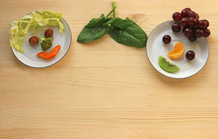 funny faces made of fruits and vegetables on bright woodの写真素材