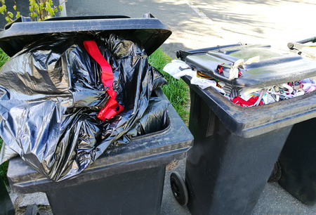 owerflowing garbage cans staning at the streetの写真素材