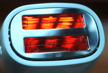 top view of a white toaster with red glowing heat elementsの写真素材