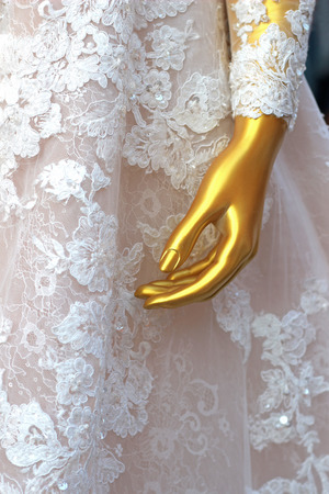 gold colored display dumming wearing a precious wedding dress, close-upの写真素材