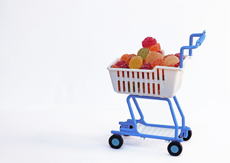 shopping cart filled with a heap of sweetsの写真素材