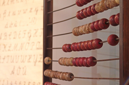 old calculation aid (abacus) and alphabet placard, close-up