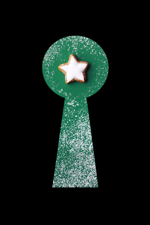 Merry Christmas: view through an apple on a cinnamon star on green background, powdered with sugarの写真素材