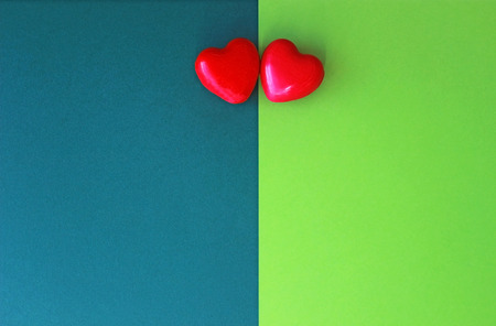Love, two red hearts side by side on green backgroundsの写真素材