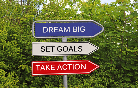 Three signs with arrow pointing in the same direction, with the message dream big, set goals, take...