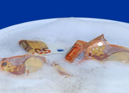 money laundering, Euro-Banknotes swimming in a bowl with soapy waterの写真素材