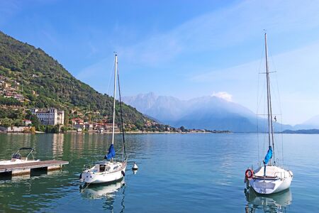 beautiful bay of Gravedona at Lake Como, Italy, with two sailboats in the foreground