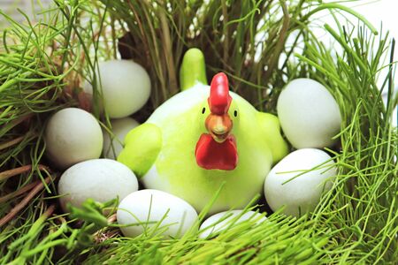 toy chicken breeding on eggs in a grass nestの写真素材