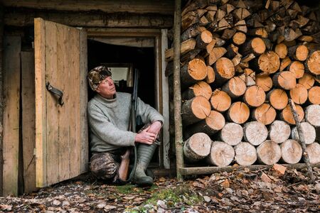 Male hunter near a hunting lodge in forestの写真素材